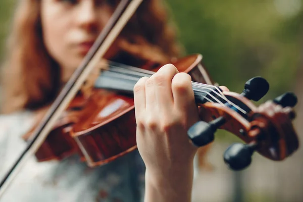 Menina bonita em um parque de verão com um violino — Fotografia de Stock