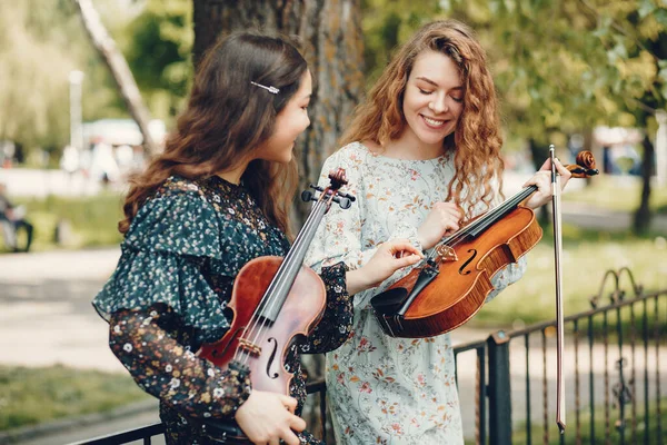 Belle e romantiche ragazze in un parco con un violino — Foto Stock