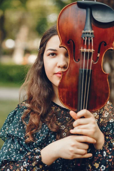 Bella ragazza in un parco estivo con un violino — Foto Stock