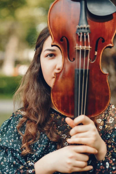 Menina bonita em um parque de verão com um violino — Fotografia de Stock