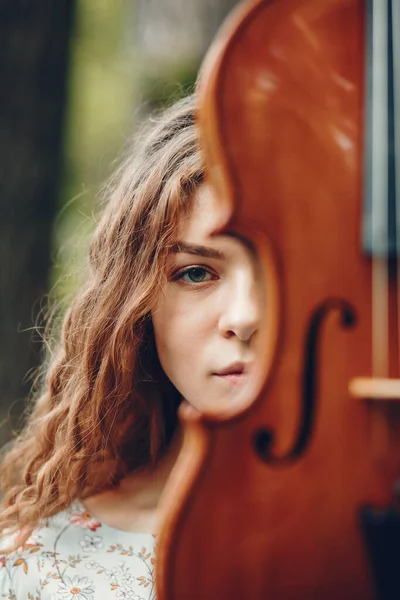 Menina bonita em um parque de verão com um violino — Fotografia de Stock