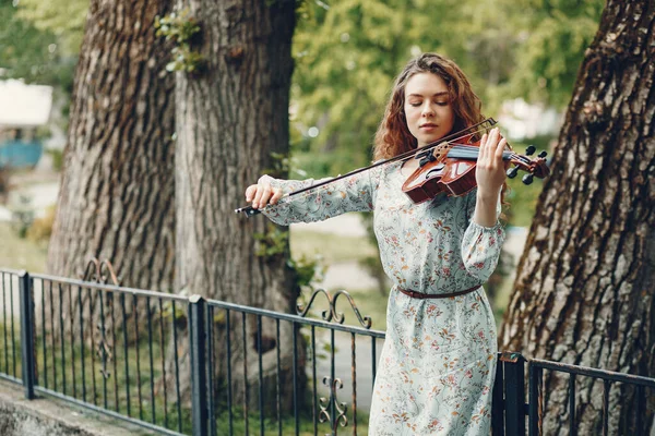 Menina bonita em um parque de verão com um violino — Fotografia de Stock