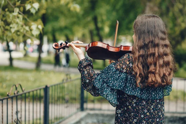 Красивая девушка в летнем парке со скрипкой — стоковое фото