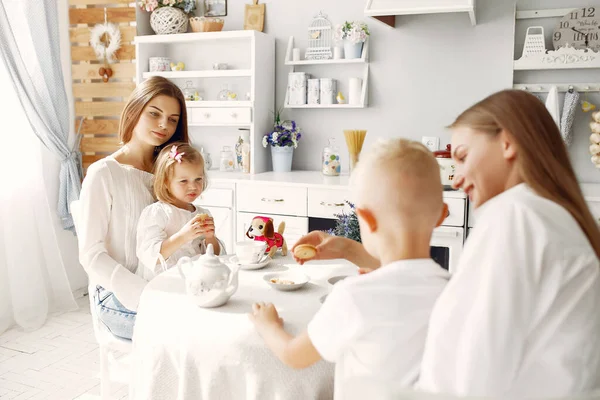 Mother with little children drinking tea at home — Stock Photo, Image