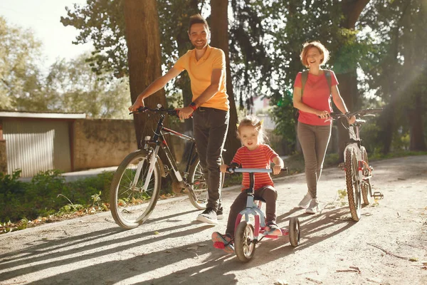 Família com uma bicicleta em um parque de verão — Fotografia de Stock