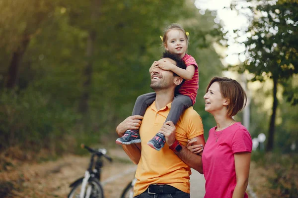 Família com uma bicicleta em um parque de verão — Fotografia de Stock