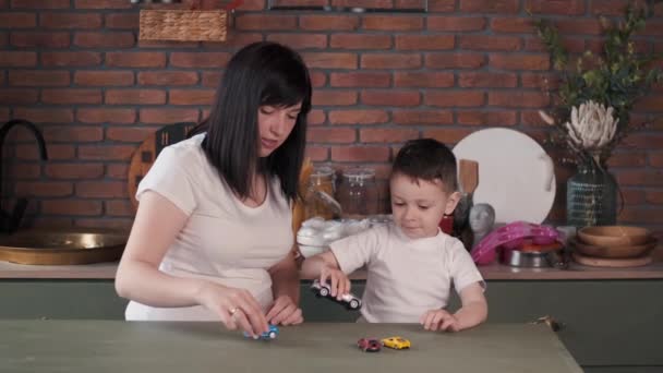 Madre e figlio giocare con auto giocattolo sul tavolo — Video Stock