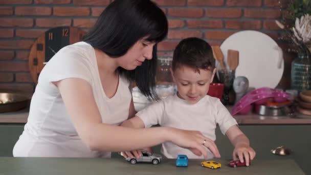 Madre e figlio giocare con auto giocattolo sul tavolo — Video Stock