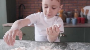 Küçük çocuk kurabiye için hamur pişirir.