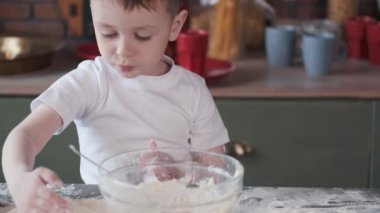 Küçük çocuk kurabiye için hamur pişirir.