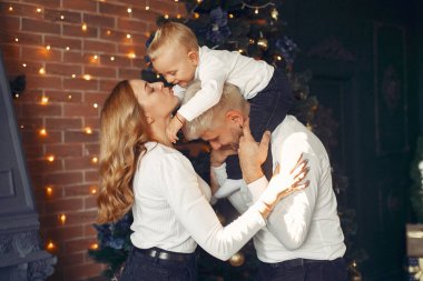 Noel ağacının yanında küçük oğlu olan bir aile.