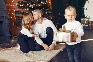 Noel ağacının yanında küçük oğlu olan bir aile.