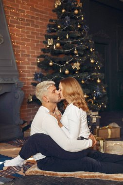 Noel ağacının yanında oturan zarif bir çift.