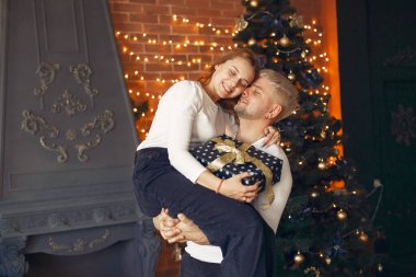 Noel ağacının yanında duran zarif çift.