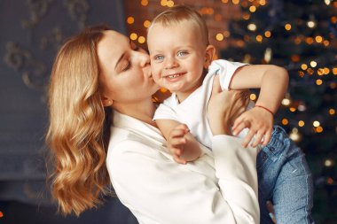 Anne ve tatlı oğlu Noel ağacının yanında evdeler.