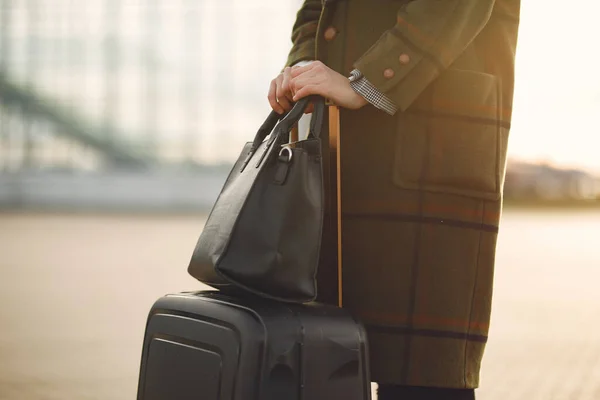 Frau mit Koffer steht am Flughafen — Stockfoto