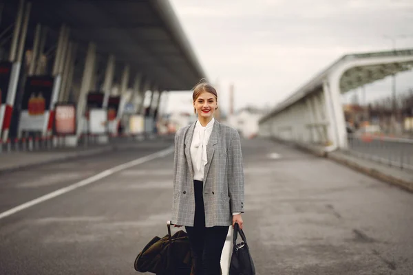 Mulher com mala em pé junto ao aeroporto — Fotografia de Stock