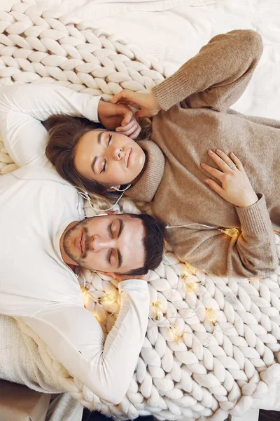 Pasangan duduk di tempat tidur di sebuah ruangan — Stok Foto