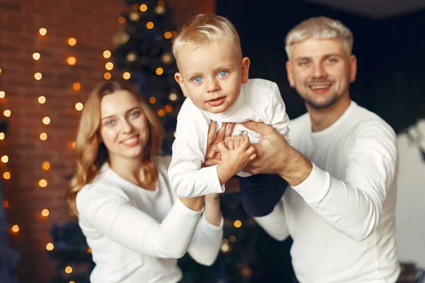 Familia con hijo pequeño en casa cerca del árbol de Navidad —  Fotos de Stock