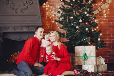 Aile Noel ağacının yanında oturuyor.