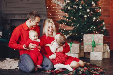 Aile Noel ağacının yanında oturuyor.