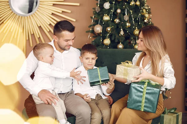 Rodina sedí doma u vánočního stromku — Stock fotografie