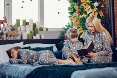 Aile bir yatakta oturuyor.