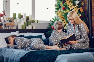 Aile bir yatakta oturuyor.