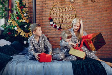 Aile bir yatakta oturuyor.