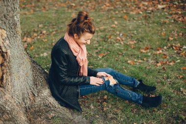 Sonbahar parkında bacağı kırık bir kız.