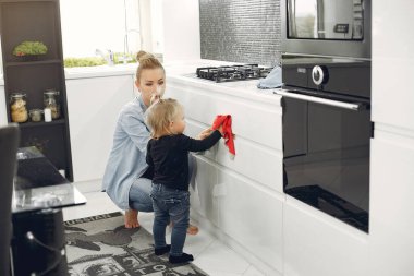 Anne ve kızı mutfağı temizliyor.