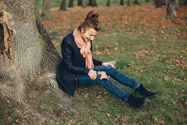Chica con una pierna rota en el parque de otoño — Foto de Stock