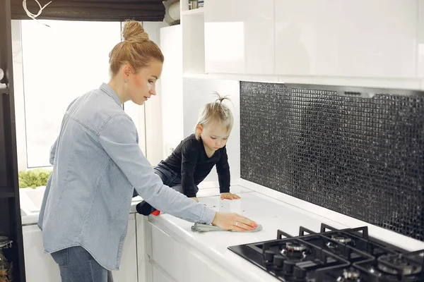 Mom and daughter clean up in the kitchen