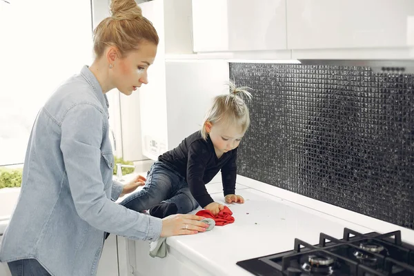 Mom and daughter clean up in the kitchen