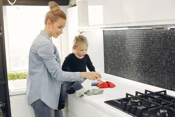 Anne ve kızı mutfağı temizliyor.