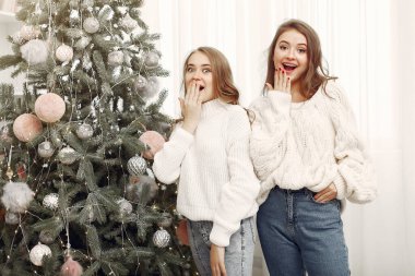 Noel ağacının yanında duran arkadaşlar