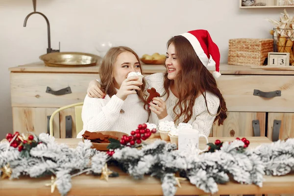 Zwei schöne Mädchen sitzen am Neujahrstisch — Stockfoto