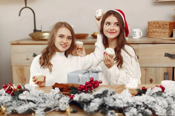 Zwei schöne Mädchen sitzen am Neujahrstisch — Stockfoto