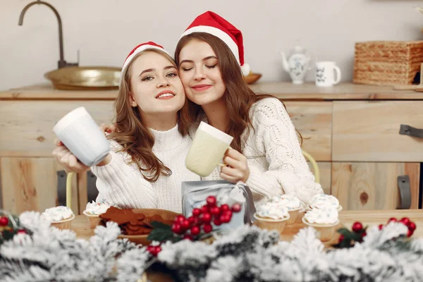 Zwei schöne Mädchen sitzen am Neujahrstisch — Stockfoto