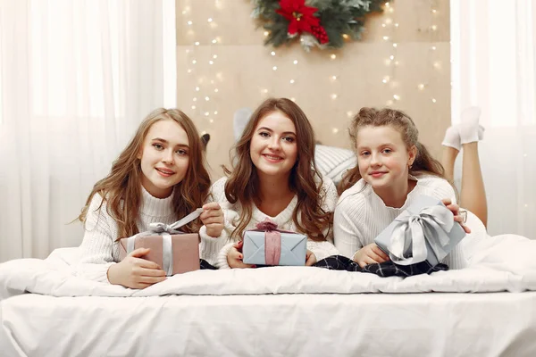 Les filles couchées sur le lit avec des cadeaux. — Photo