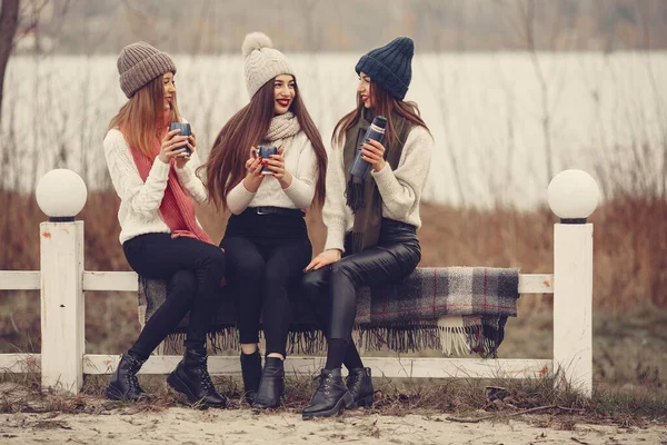 Женщины в зимнем парке без снега с термосом и чаем — стоковое фото