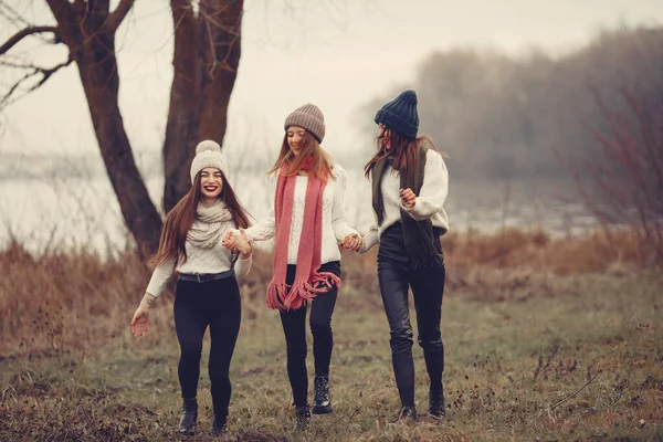 Thre vänner går i en vinterpark utan snö — Stockfoto
