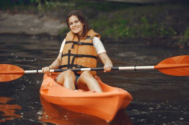 Gölde kanoyla kürek çeken bir kadın