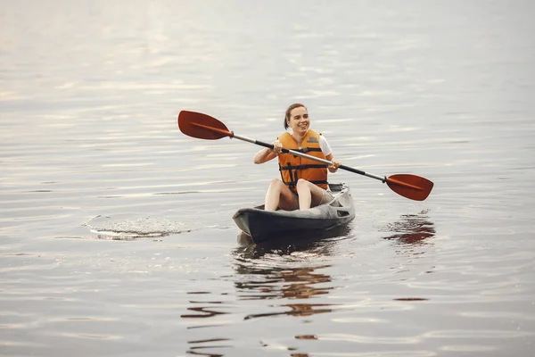 Mulher remando em um lago em um caiaque — Fotografia de Stock