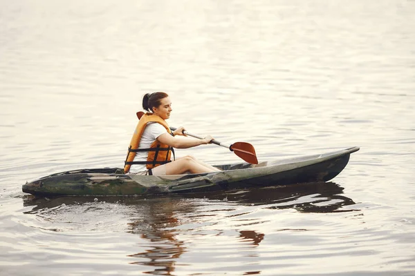 Γυναίκα κουπιά σε μια λίμνη σε ένα καγιάκ — Φωτογραφία Αρχείου