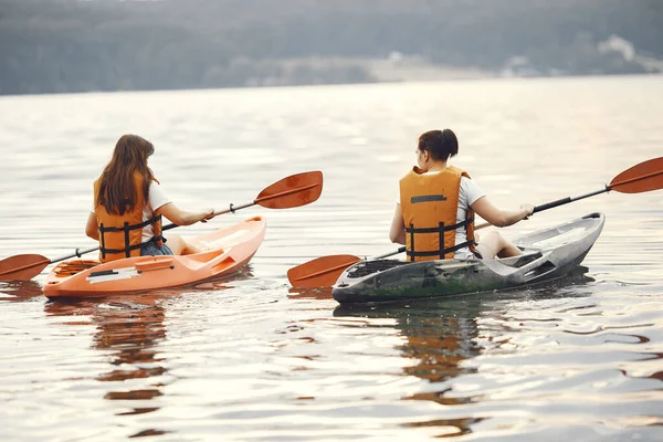 Mujeres remando en un lago en un kayak — Foto de Stock