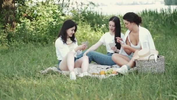 Grupo de meninas amigas fazendo piquenique ao ar livre e jogando um jogo de cartas — Vídeo de Stock