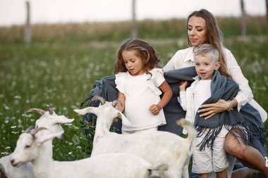 İki çocuklu anne parkta keçi besliyor..