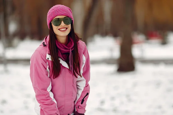 Vrouw in wintersportkleding kijkend naar camera — Stockfoto