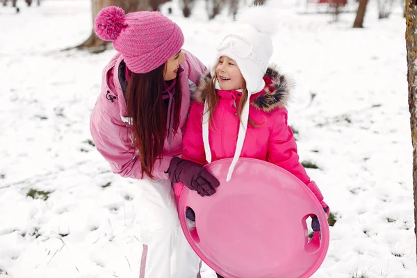 Madre e bambino in abiti invernali giocano nel parco invernale — Foto Stock